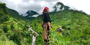 Native standing in beautiful mountain scenery from our North Vietnam Tribal Culture Tour